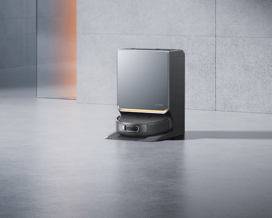 Robotic vacuum cleaner on a reflective floor with a gray tiled wall background